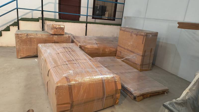Sofa set wrapped in corrugated sheet before loading